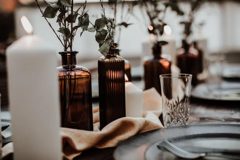 Braune geriffelte Apothekerflaschen mit Eukalyptus und Kerzen