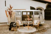 Rattan Lounge mit Sesseln vor einem alten VW Bus
