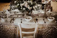 Weißer Plankentisch mit Blumen und Goldbesteck