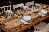 Heller Rustiktisch mit weißer Schale und Blüten