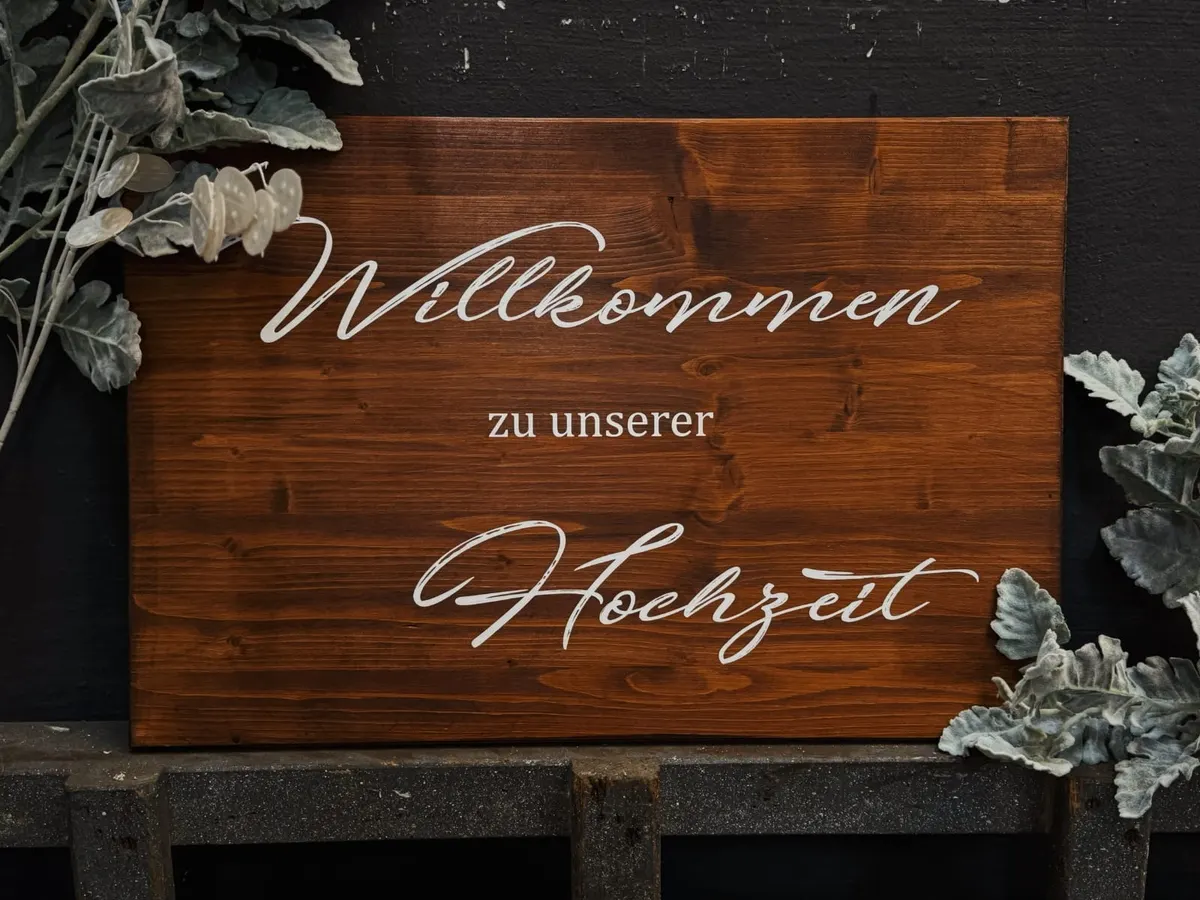 Holzschild mit dem Schriftzug Willkommen zu unserer Hochzeit