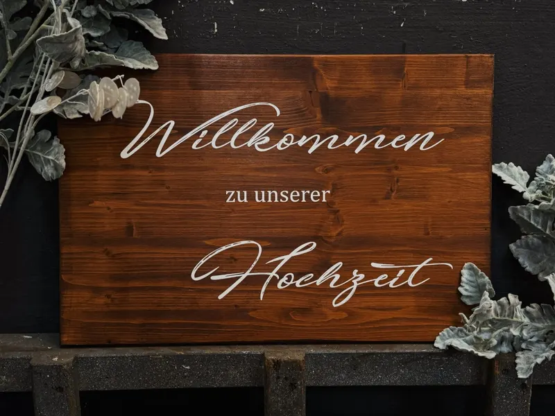 Holzschild mit dem Schriftzug Willkommen zu unserer Hochzeit